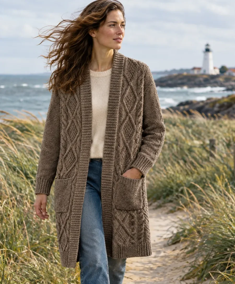 A woman in the Fastnet Diamond Long Cardigan on a windy dune path